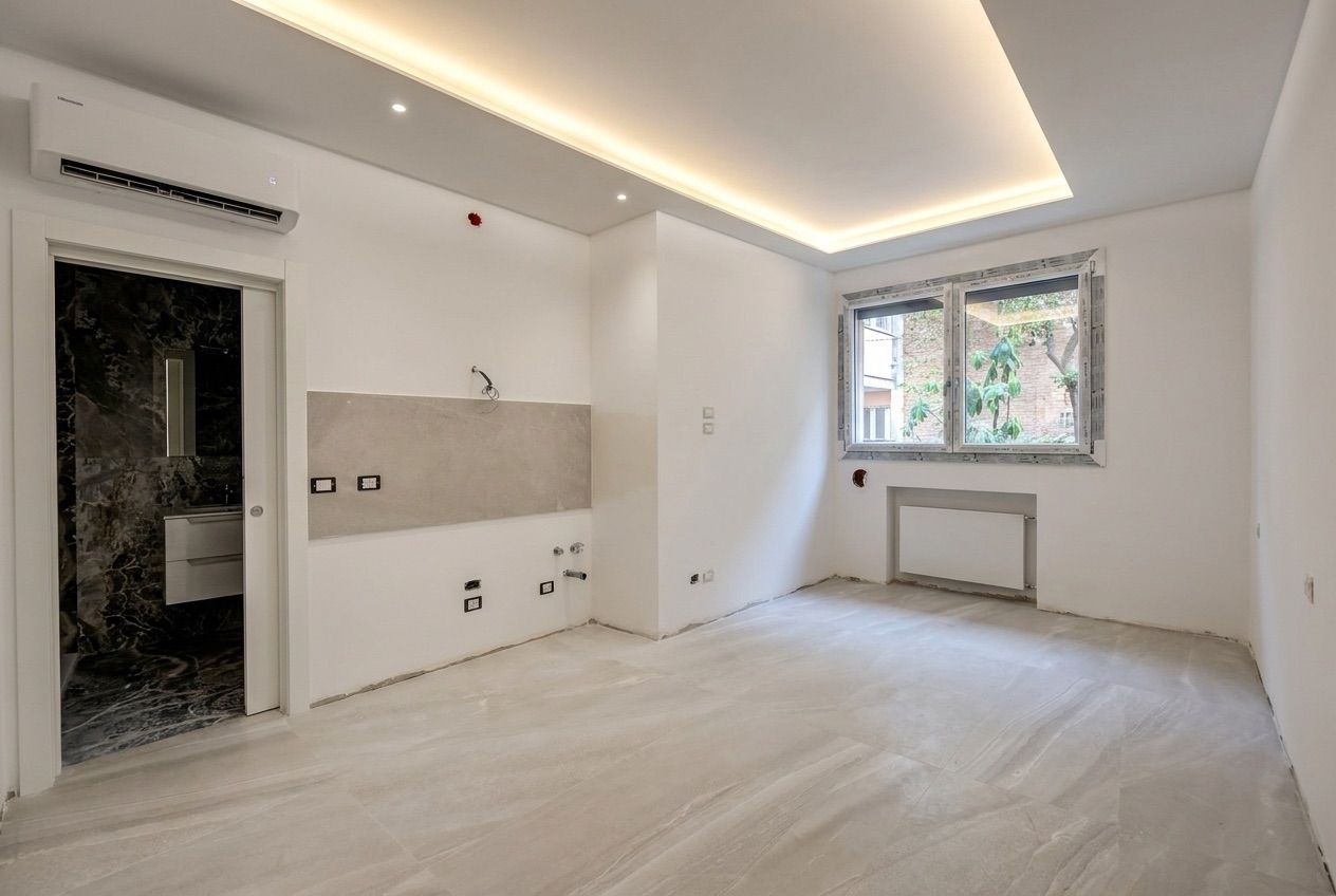 Ambiente ristrutturato con pavimento in gres chiaro, controsoffitto luminoso e bagno in marmo scuro